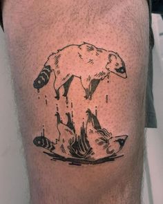 a man's leg with a bear and fish inked on the calf side