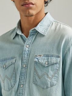 CLASSIC STYLE MADE MODERN Offering a classic look with unlimited potential, our men’s long-sleeve Western denim shirt will instantly elevate your everyday rotation. It’s crafted from 100% cotton for long-lasting quality and washed for softness. This collared shirt comes with two chest pockets with flaps, pearl snaps, and our signature ‘W’ embroidery. It features a comfortable fit through the shoulders and a regular fit through the body for a look that feels very off-duty and put-together all at Distressed Long Sleeve Tops For Rodeo, Long Sleeve Washed Tops For Rodeo, Western Denim Shirt Men, Western Denim Shirt, Denim Shirt Men, Wrangler Shirts, Collared Shirt, Men's Shirts, Off Duty