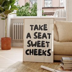 a sign that says take a seat, sweet cheeks next to a pile of books