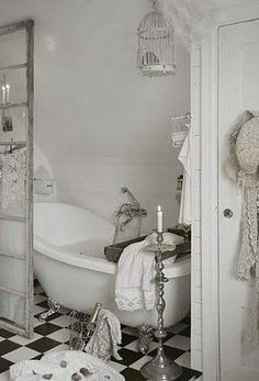 an old fashioned bathtub in the corner of a room with a checkered floor