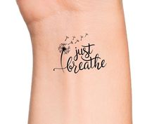 a wrist tattoo with the words just breathe on it