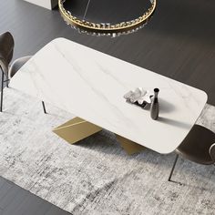 a white marble table with two chairs and a vase on the floor next to it