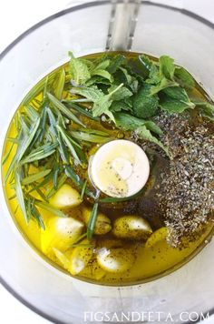 an overhead view of a food processor with vegetables and herbs in the blender for making soup