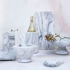 white marble bathroom accessories with bottle and soap dispenser on countertop next to it