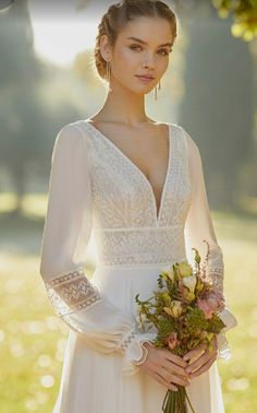 a woman in a white wedding dress holding a bouquet of flowers and wearing long gloves