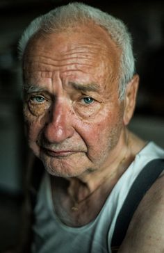 black and white photograph of an older man with wrinkles on his face, looking at the camera