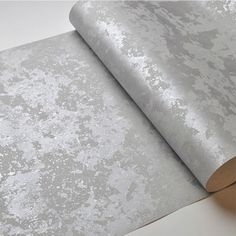 a roll of metallic paper on top of a white table