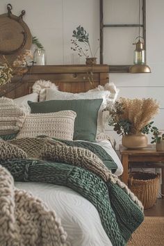 a bed with green and white blankets on top of it next to a wooden table