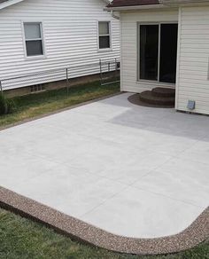 a concrete patio in front of a white house