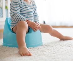 a baby sitting on top of a blue potty