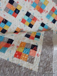 two quilts are laying on top of each other, one has an orange and blue patchwork design