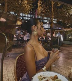 a woman sitting at a table with a plate of food