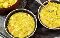 two bowls filled with soup sitting on top of a table