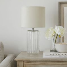 a table with a lamp, bowl and flowers on it