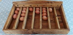 a wooden crate filled with brown eggs sitting on top of a blue tablecloth covered floor