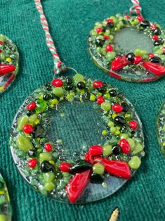 some glass ornaments are sitting on a green tablecloth with candy canes in the shape of wreaths