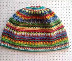 a multicolored crocheted hat sitting on top of a table