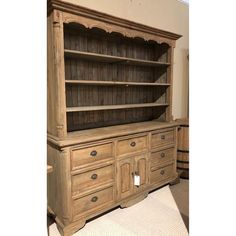 an old wooden cabinet with drawers and cupboards on the bottom, next to a rug