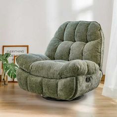 a green recliner chair sitting in a living room next to a potted plant