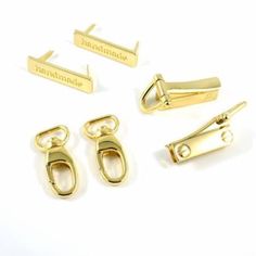 four pairs of gold colored metal clips and shacks with nameplates on them