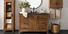 a bathroom with wooden cabinets and a round mirror