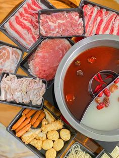 various foods are being prepared in trays on a table with chopsticks and sauce