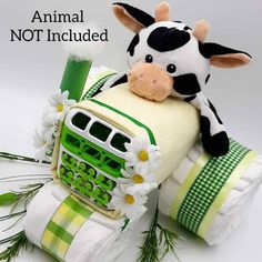 a stuffed cow sitting on top of a green and white blanket