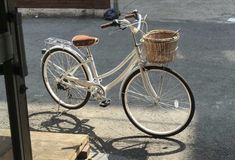 a white bicycle parked next to a building