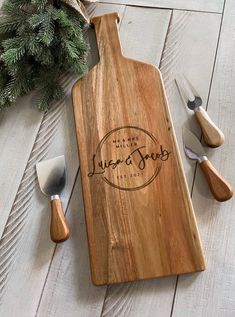 a wooden cutting board sitting on top of a white floor next to utensils