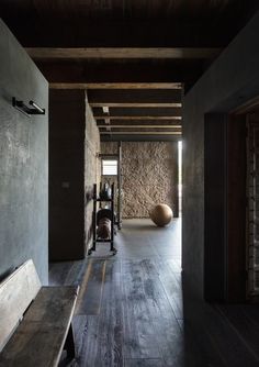 an empty room with wooden floors and stone walls