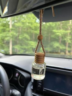 a car dashboard with a glass bottle hanging from the dash line and a rope attached to it