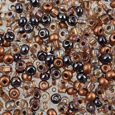 some brown and black beads on a white surface