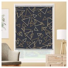 a living room with a large window covered in black and gold geometric wall coverings