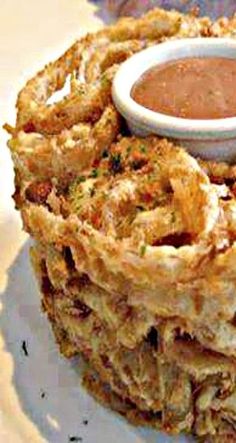 a stack of fried food with dipping sauce on top