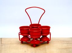 four red pots are stacked on top of each other