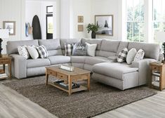 a living room with a sectional couch and coffee table in front of the sofa is surrounded by other pieces of furniture