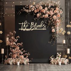 the bridals sign is surrounded by flowers and candles in front of a black backdrop