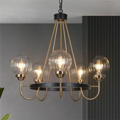 a chandelier with five clear globes hanging from it's metal frame