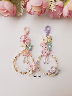 two pairs of earrings with flowers on them and pearls hanging from the bottom of each ear