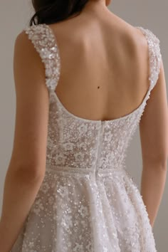 the back of a woman's wedding dress with sequins