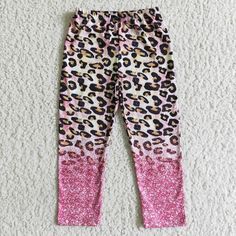 the pink and black leopard print leggings are laying on top of white carpet