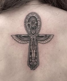 the back of a woman's neck with a cross and an eye on it