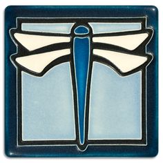 a blue and white tile with an image of a dragonfly on it's wings