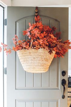 a basket filled with leaves hanging from the side of a door