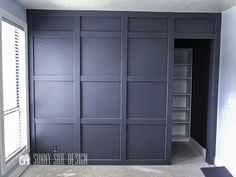 an empty room with blue walls and shelving