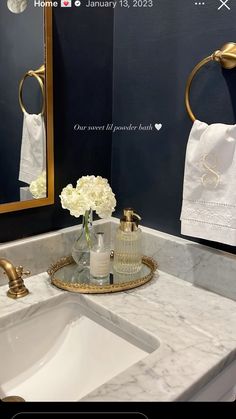 a white sink sitting under a mirror next to a gold faucet mounted on a wall