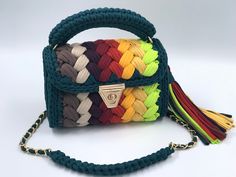 a multicolored handbag with a tasselled handle on a white background