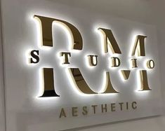 the sign for studio aesthetic is lit up in white and gold letters that spell out the word studio aesthetic