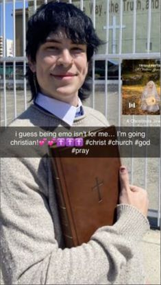 a man holding a bible in front of a fence