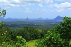 the mountains are in the distance with trees on each side and blue sky above them